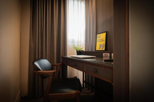 a room with a desk and a chair next to a window at Dream Mansion Hotel in Taichung