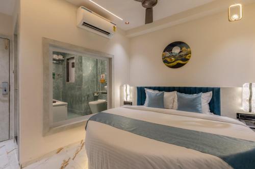 a bedroom with a large bed and a bathroom at Hotel Windsor Castle in Mumbai