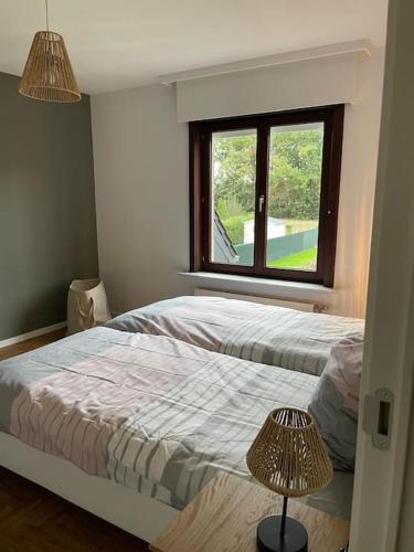 a bedroom with two beds and a window at Xiu's home in Wielsbeke