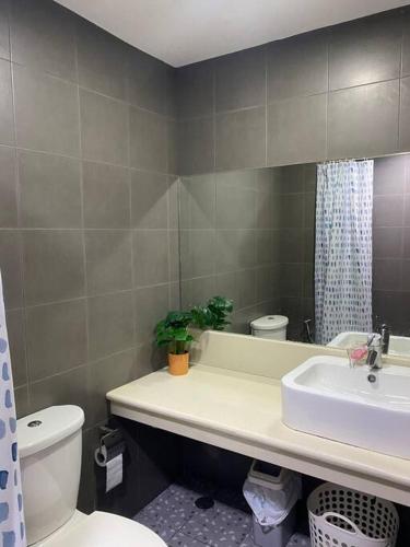 a bathroom with a sink and a toilet and a mirror at 2 Bedroom Mactan Beach Condo, La Mirada Residences in Lapu Lapu City