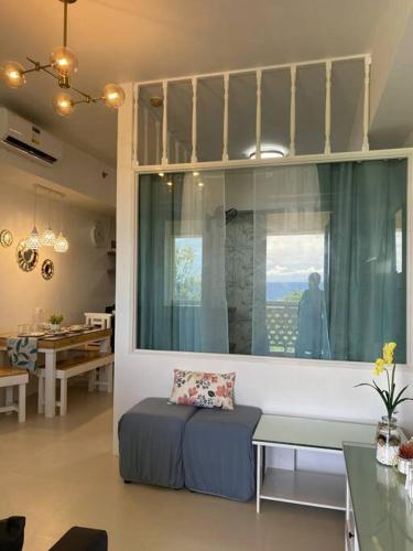 a living room with a couch and a window at 2 Bedroom Mactan Beach Condo, La Mirada Residences in Lapu Lapu City