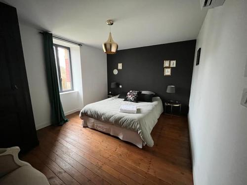 une chambre avec un lit et une grande fenêtre dans l'établissement Le gite dErin, à Saint-Yrieix-sous-Aixe