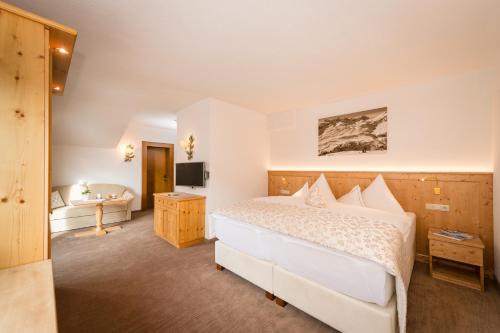 a hotel room with a bed and a television at Hotel Enzian in Zürs am Arlberg