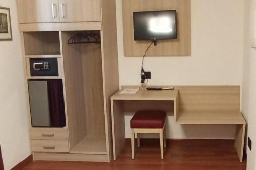 a room with a desk with a tv on a wall at Il Tesoro Pompeiano in Pompei