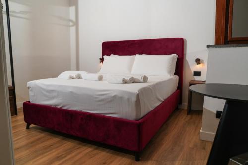a bedroom with a large bed with a red frame at Il Tesoro Pompeiano in Pompei