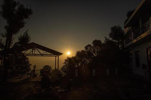 a light in the sky behind a building at night at Maatidera Resort Kanatal The Boutique stay in the Lap of Himalayas in Kanatal