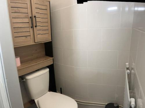 La salle de bains est pourvue de toilettes blanches et d'une armoire. dans l'établissement Au calme Proche centre ville, jardin et commodités, à Bourges