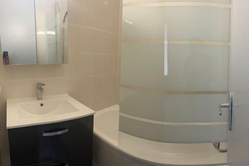 une salle de bain blanche avec lavabo et douche dans l'établissement Au calme Proche centre ville, jardin et commodités, à Bourges