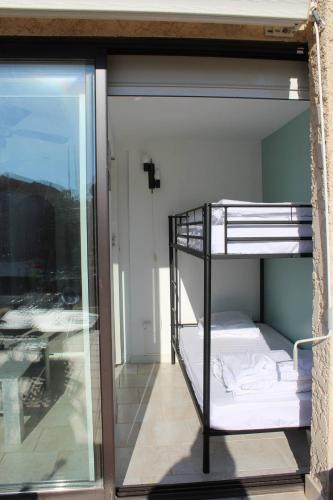 Ce lit superposé se trouve dans un dortoir doté d'une fenêtre. dans l'établissement Face Lagune superbe appartement de plain pied avec parking - 6BAIE12, à Saint Cyprien Plage