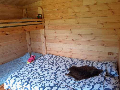 a room with a bed in a log cabin at Tree House Fluffy Horns - Namiņš Kokos Pūkainie Ragi in Plieņciems
