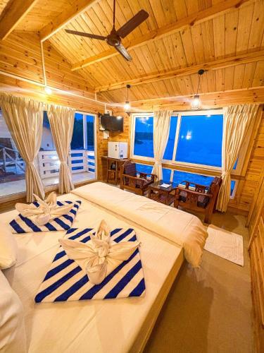 a bedroom with two beds with blue and white striped towels at Red Crab Eco Resorts in Cabo de Rama