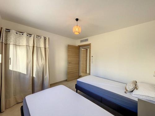 une chambre avec deux lits et une fenêtre dans l'établissement Appartement T3 dans une résidence neuve, à Calvi