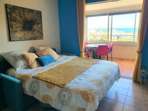 a bedroom with a bed and a table and a window at L'escapade Côte Bleue vue mer panoramique in Sausset-les-Pins