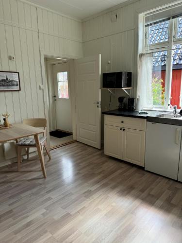 a kitchen with a table and a dining room at Tollgaarden Gjestegaard in Larvik