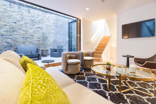 a living room with a couch and a tv at Soho Mews House in London