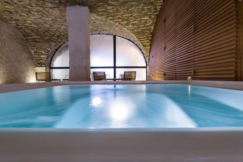 - une grande piscine dans une grande pièce avec des chaises dans l'établissement Hôtel du Golf, à Mallemort