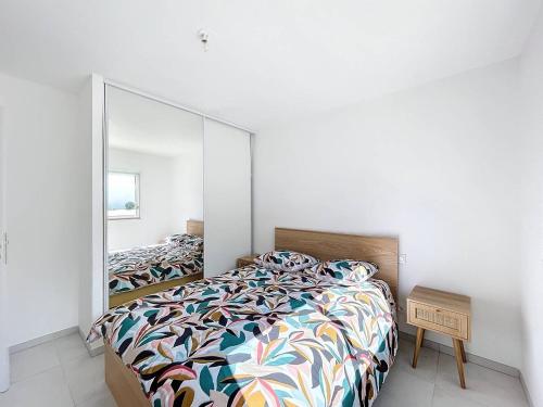 - une chambre avec un lit et un grand miroir dans l'établissement Appartement dans résidence avec piscine, à Calvi