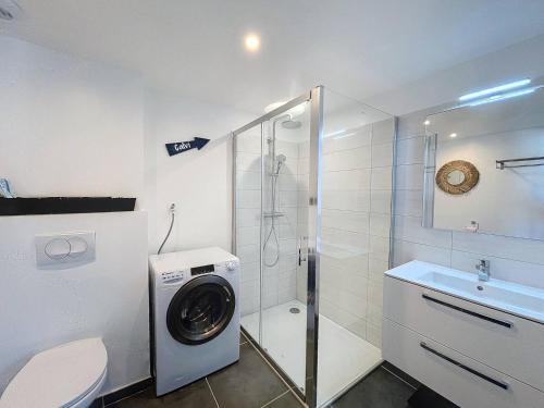 une salle de bain avec une machine à laver et un lavabo dans l'établissement Magnifique T2 vue sur la baie de Calvi, à Calvi