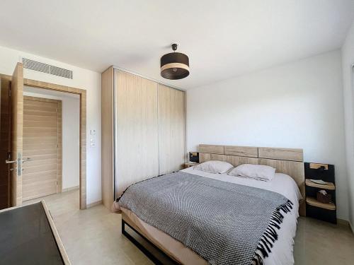 une chambre avec un grand lit dans une pièce dans l'établissement Appartement T2 avec vue mer et citadelle, à Calvi