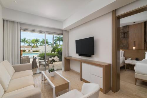 a living room with a television and a living room with a couch at Paradisus Grand Cana, All Suites - Punta Cana -All Inclusive in Punta Cana