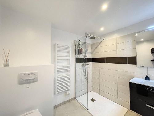 une salle de bain blanche avec une douche et un lavabo dans l'établissement Appartement T2 dans une résidence avec piscine, à Calvi