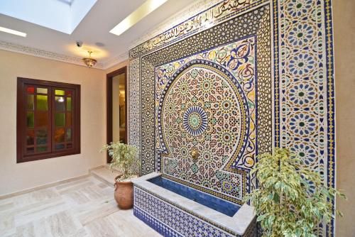 a room with a wall with a large mosaic wall at Blue Sky Hotel in Fez