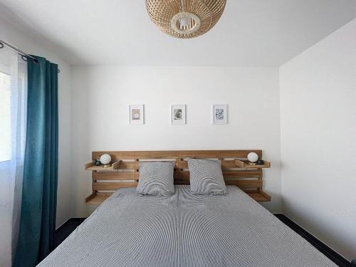 - une chambre blanche avec un lit et deux oreillers dans l'établissement Appartement avec vue mer et citadelle, à Calvi