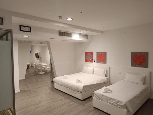 セグラーテにあるFasthotel Linateのベッド2台付きの部屋、テーブル付きのダイニングルームが備わります。