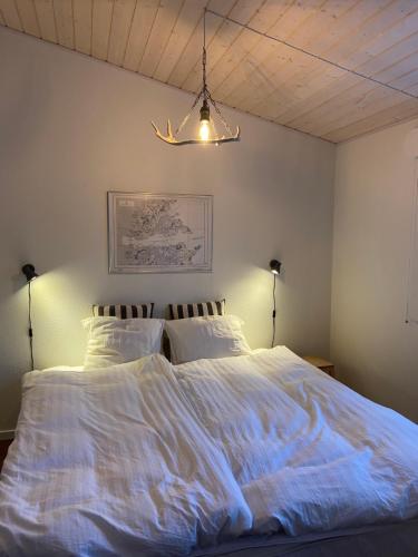 a bedroom with a large bed with white sheets at Ilulissat Stay - Seawatch Retreat in Ilulissat