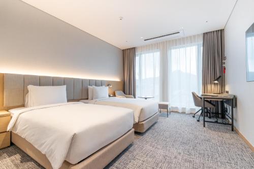 a hotel room with two beds and a desk at Stanford hotel Andong in Andong