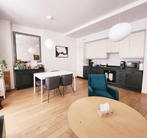 un salon avec une table et des chaises et une cuisine dans l'établissement Homeloveparis, à Paris