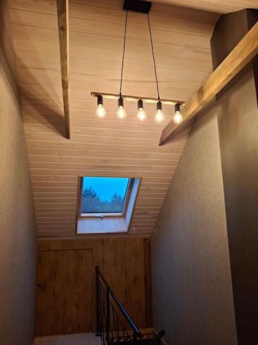a room with a window and a staircase with lights at Guest house Kalnieši in Madona