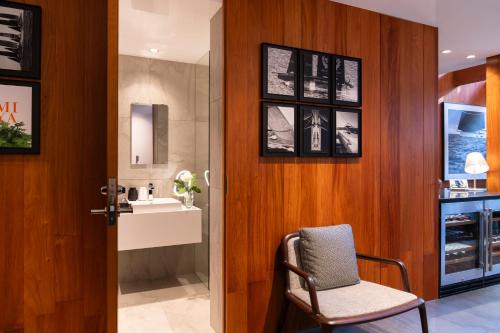 a bathroom with a sink and a chair in a room at Miya Townhouse by Reflections in Kyoto