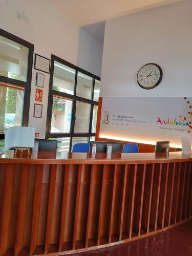 a waiting room with a clock on the wall and chairs at Escuela-Hotel Convento Santo Domingo in Archidona