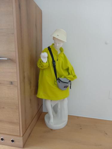 a mannequin in a yellow raincoat standing on a toilet at Paradies in Bad Radkersburg