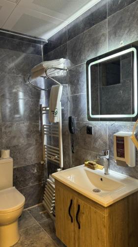 a bathroom with a sink and a toilet and a mirror at El Baboos Hotel in Bostaniçi
