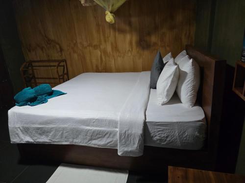 a bedroom with a bed with white sheets and pillows at Ceylon wilpattu safaris & lodging in Wilpattu