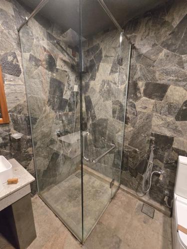 a shower with a glass door in a bathroom at Ceylon wilpattu safaris & lodging in Wilpattu