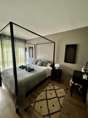 une chambre avec un grand lit à baldaquin dans l'établissement Confort cosy, à Paris