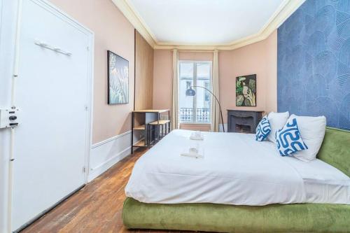 une chambre avec un grand lit blanc avec des murs bleus dans l'établissement Studio confortable au centre Paris 14ème, à Paris
