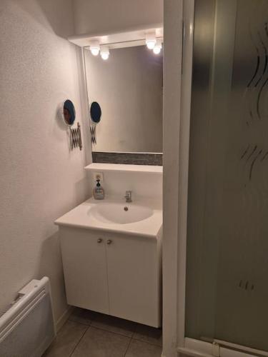 une salle de bain blanche avec un lavabo et un miroir dans l'établissement LE COEUR VILLAGE - Bord de Mer, 70m2, à Saint-Georges-de-Didonne