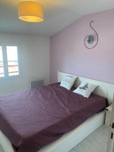 une chambre avec un lit avec une couette violette dans l'établissement LE COEUR VILLAGE - Bord de Mer, 70m2, à Saint-Georges-de-Didonne