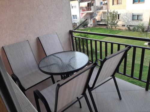a table and chairs on a balcony with a view of a building at Stan na dan Ilicka in Brčko