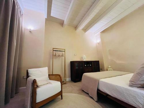 a bedroom with two beds and a chair at Apartment Antiche Mura in Specchia