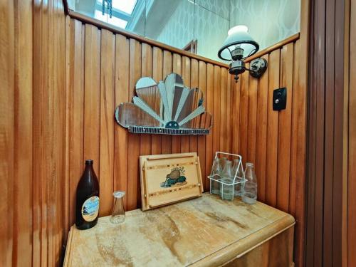 a wooden wall with a table with a picture and a lamp at Te Anau Retro Retreat in Te Anau