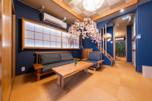 a living room with a couch and a table at ちよ 桜と過ごすお部屋 usjまで電車で10分 4つの寝室 お風呂2台 トイレ4台 in Osaka