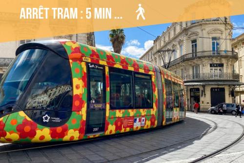 a colorful tram on a street in a city at Youmi - Appartement Calme avec Jacuzzi et Clim à 5min de la Comédie, Tram à 200m in Montpellier