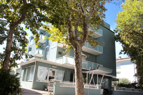 a green building with trees in front of it at King Hotel in Cesenatico