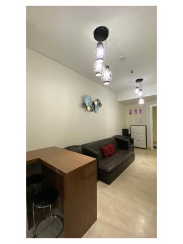 a living room with a couch and a table at Podomoro Pool View Exclusive Apartment-5th Floor-Min 2N in Medan
