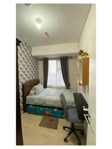 棉兰Podomoro Exclusive Pool View Apartment-5th Floor-Min 2N的一间带床和书桌的小卧室